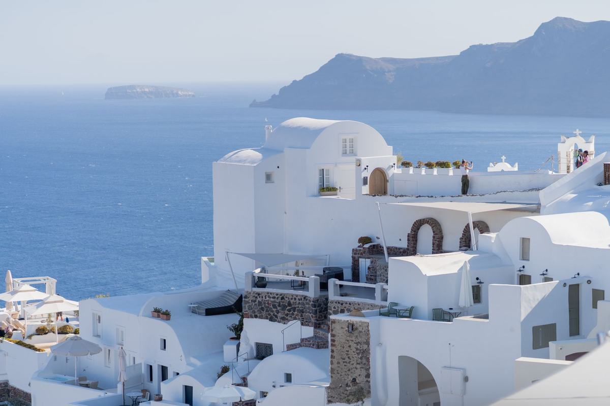 Whitewashed buildings on a hillside overlooking the Aegean Sea in Santorini, Greece