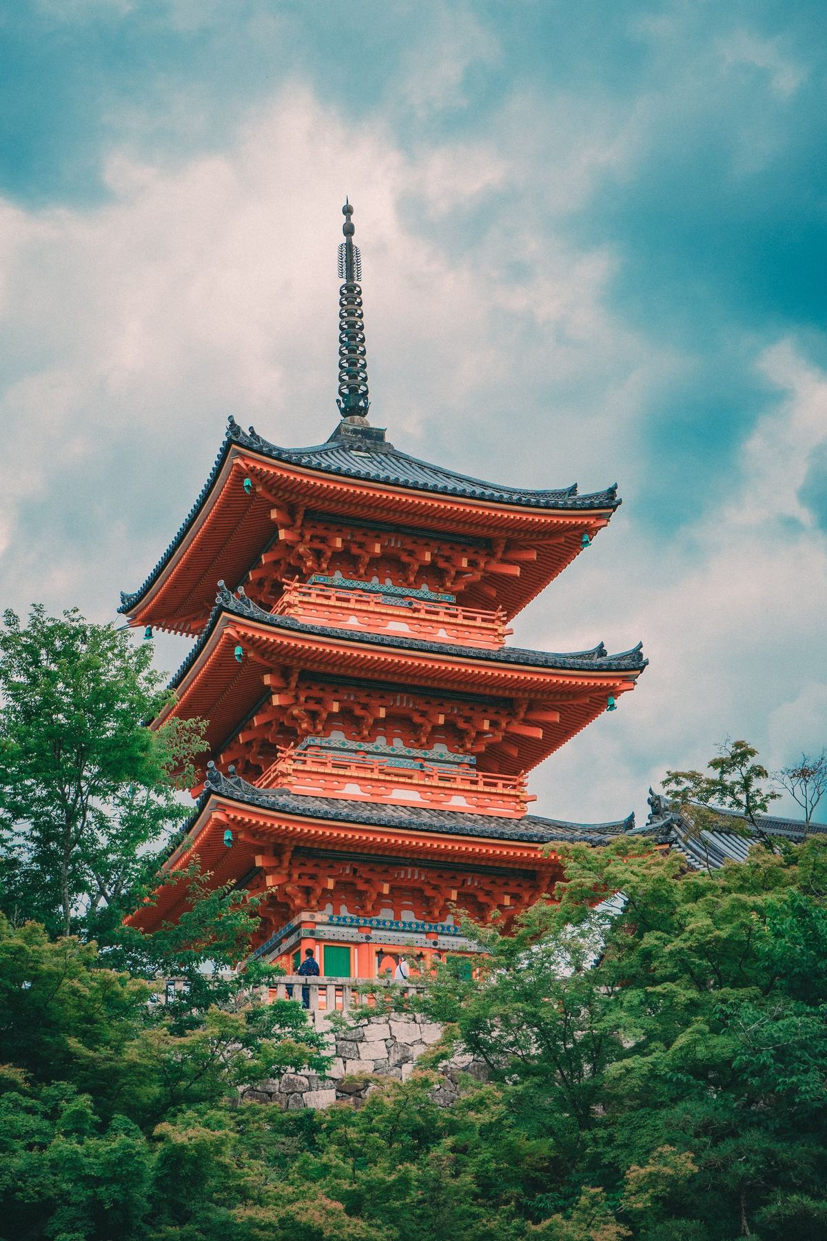 The red pagoda of Kiyomizu-dera temple among trees in Kyoto, Japan