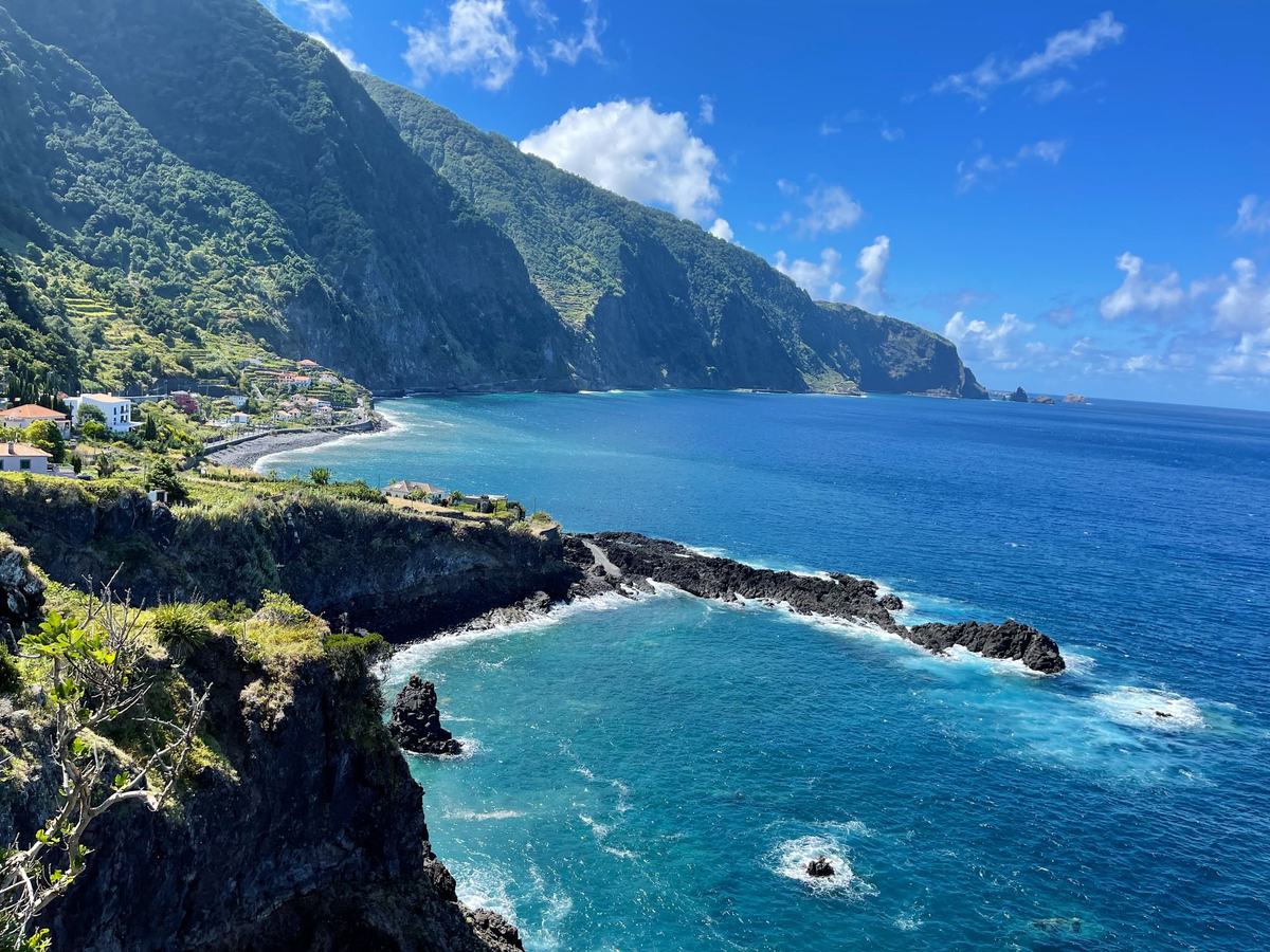 A turquoise bay below steep green cliffs near Seixal on Madeira